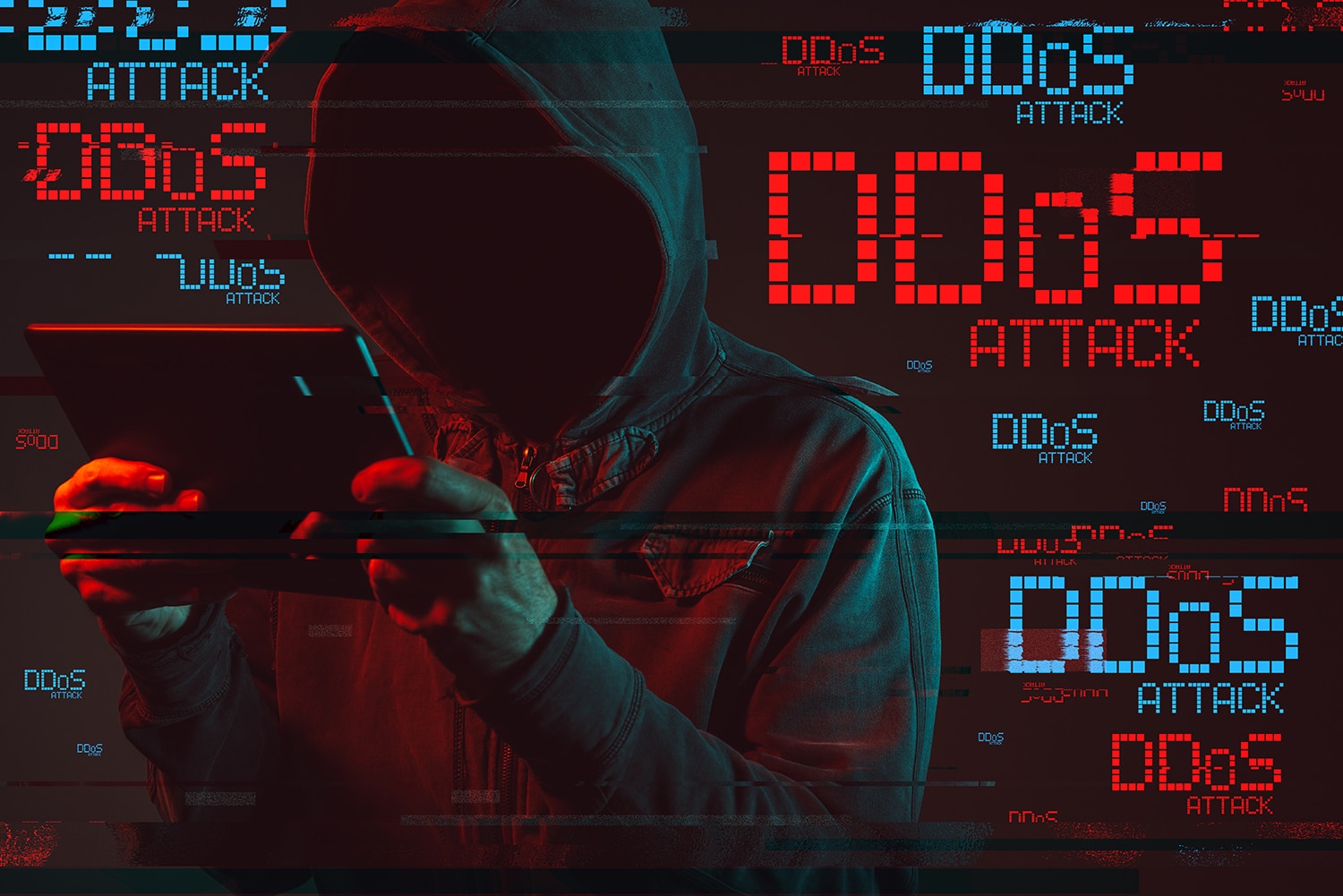 Distributed denial of service or DDoS attack concept with faceless hooded male person using tablet computer, low key red and blue lit image and digital glitch effect